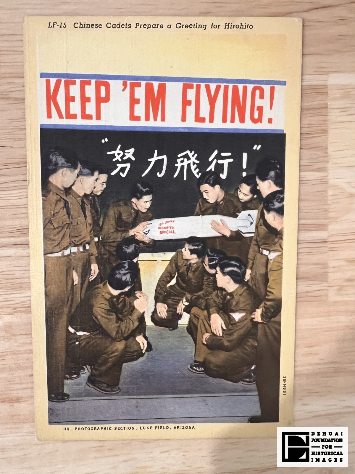 TFA-CA-126 — Face of the card: the LF-15 caption line, the KEEP ’EM FLYING! band, the white 努力飛行！ [Strive in flight!] on the dark panel, the lettered bomb, and the Luke Field photographic credit.