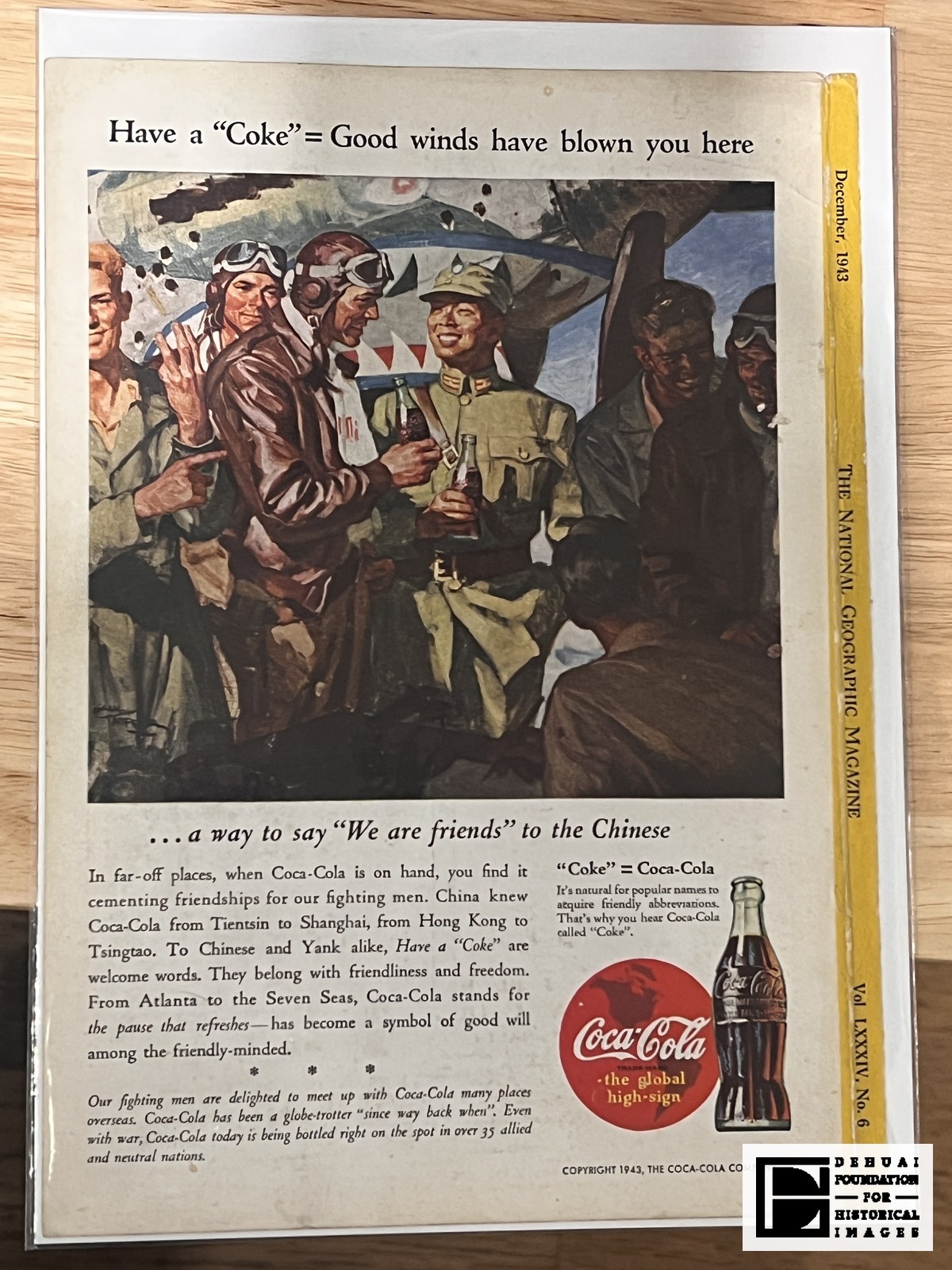 TFA-CA-132 — The advertisement, photographed face up in its sleeve. The yellow spine strip along the right edge carries the issue line “December, 1943 | THE NATIONAL GEOGRAPHIC MAGAZINE | Vol LXXXIV, No. 6”; whether it belongs to this leaf is not established.